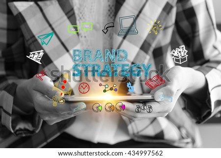 business holding a smart phone with BRAND STRATEGY text on black and white background ,business analysis and strategy as concept