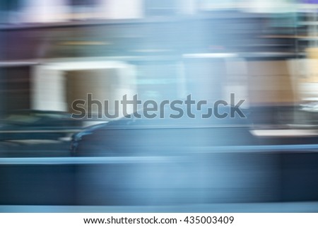 Reflection of a speeding car in an office buildings glass wall. Modern hybrid uber, lyft or taxify taxi car rushing in city streets, motion blur from speed Royalty-Free Stock Photo #435003409