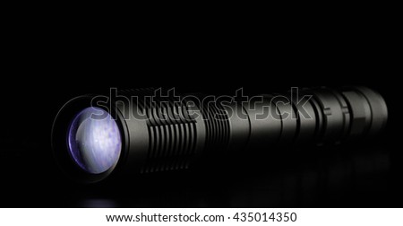 tactical police and military flashlight on black background.