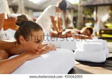 Spa Couple Massage. Beautiful Happy Smiling Woman And Healthy Man Enjoying Relaxing Body Massage Treatment Outdoors At Beauty Salon. People At Romantic Day Spa Resort. Health Care And Relax Concept Royalty-Free Stock Photo #435062005