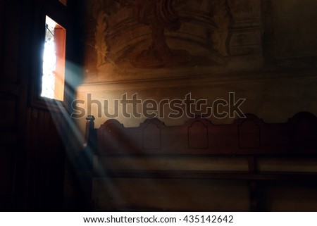 light falling through window in old church on wooden bench, peaceful moment