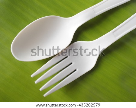 bio plastic spoon and fork on banana leaf back ground