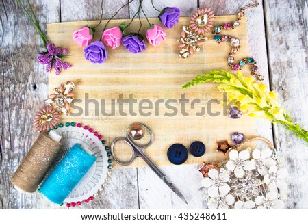 Plastic berries, flowers, beads and instruments on white wood background