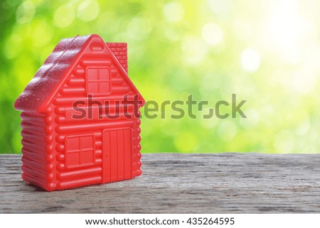 red model of house as symbol on sunny background
