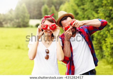 Picture of young couple planting organic tomatoes