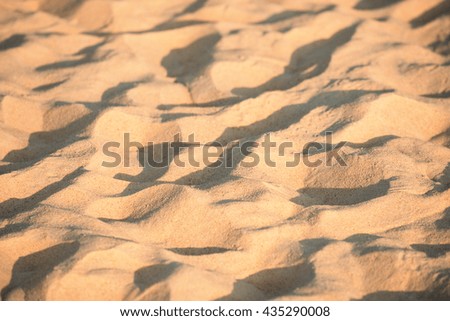 Blurred background image of sea sand and sun, Blurred picture with partly visible texture of small stones and sand seashore lit by light rays of the evening sun, Beach, seashore, Light warm tone