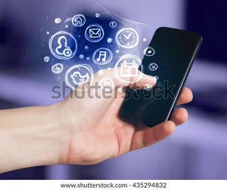 Hand holding smartphone with glowing mobile app choices