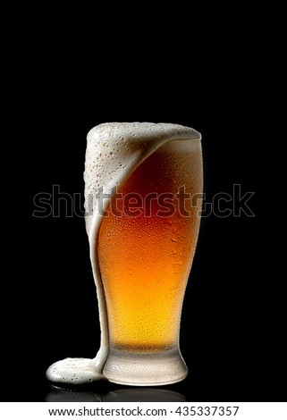 Fresh beer in a glass on a black background. The concept of food. Royalty-Free Stock Photo #435337357