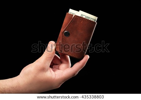 Man holding wallet on black background