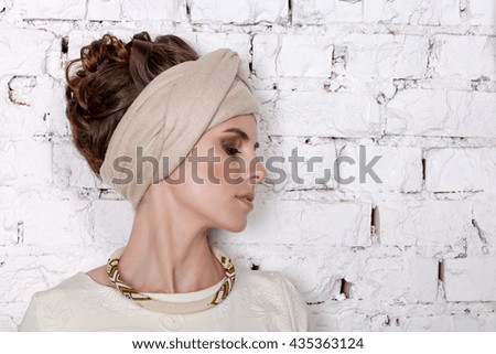Portrait of a girl with decoration of beads in a turban  beige color