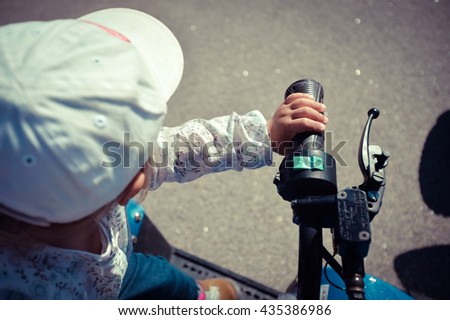 Closeup on small child riding a quad bike on sunny outdoors background, closeup 