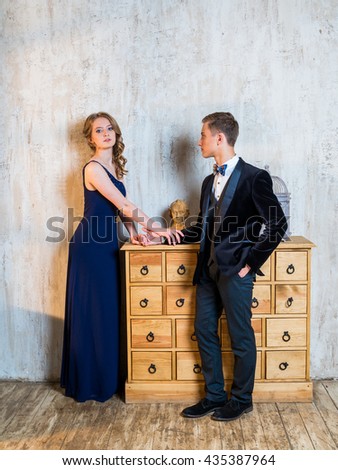 Beautiful Russian couple: a young man in a tuxedo with a bow tie and a girl in an elegant evening dress