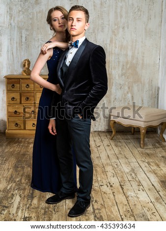 Beautiful Russian couple: a young man in a tuxedo with a bow tie and a girl in an elegant evening dress