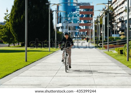 Young man riding bicycle in modern city