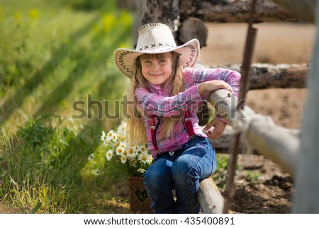Smiling Cowboy Girl with daisies