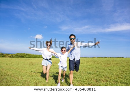 Happy family  running together on the grass Royalty-Free Stock Photo #435408811