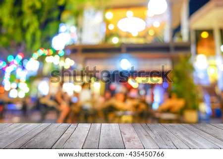 Old wooden table with blur light bokeh background at night , empty tabletop ready for product advertising