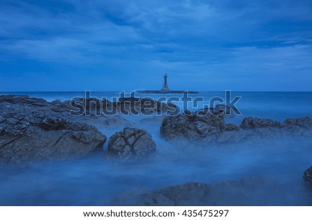 After sunset in village Razanj Croatia Europe. Landscape and nature. Adriatic Sea at dusk. Calm summer evening with beautiful colors. Cloud, sky, rock, stone, reef and lighthouse. Long exposure.