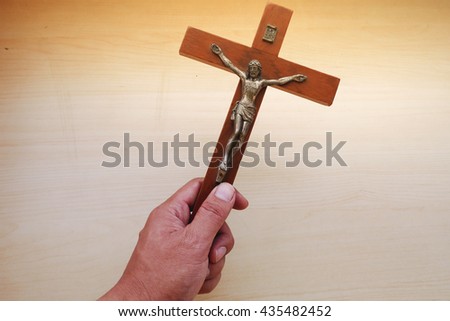Hands hold the wooden cross