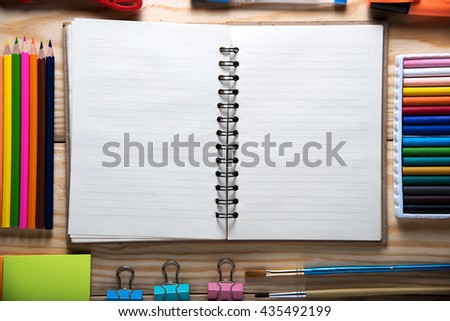 Desk with stationary and with blank notebook on wooden background. back to school concept
