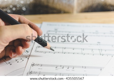 Close-up music sheets and pencils background. Musical concept background: macro view of white score sheet music with notes. Sheet Music Background Musical Notes with selective focus. - Vintage Tone.