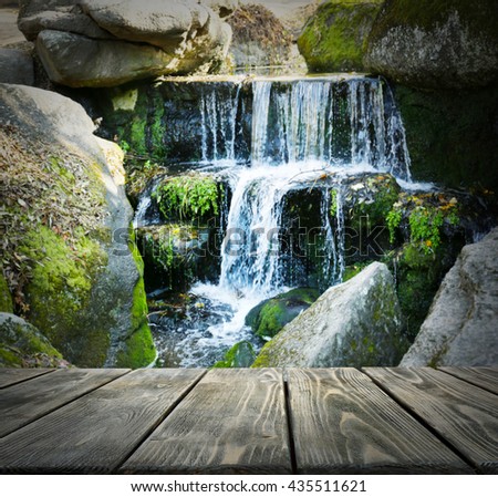 Empty wooden table on waterfall background. Space for your montage