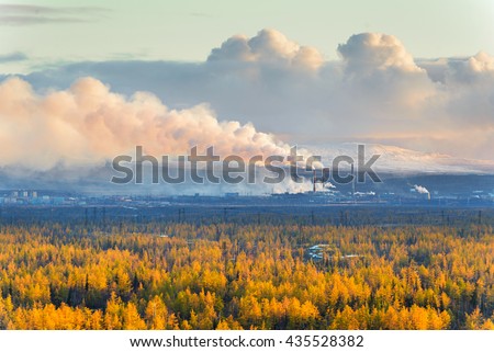 Smokestack that pollute the atmosphere. Ecological catastrophy. Polar tundra, deep autumn. Sunset, bad lighting conditions.  Royalty-Free Stock Photo #435528382