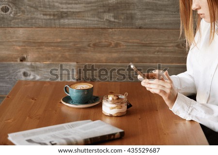 People, leisure and technology concept: young woman photographing sweet dessert on mobile phone, hipster girl taking photo of her morning breakfast using cell phone camera while sitting in cafe