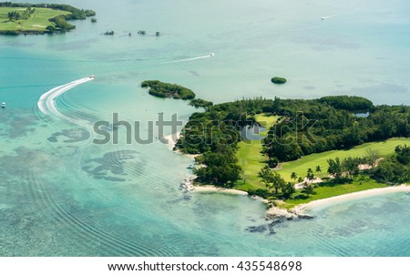 Aerial picture of the east coast of Mauritius Island. Beautiful lagoon of Mauritius Island shot from above. Boat sailing around l'ile aux Cerfs. 