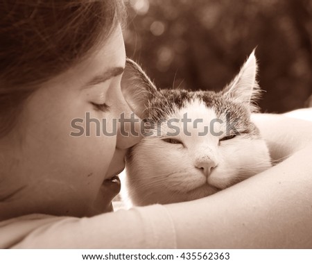 teen girl hug cat close up sepia retro portrait on the summer garden background