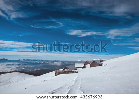 Carpathian mountain village with old rustic houses covered by snow. Frosty winter day. Ukraine, Europe