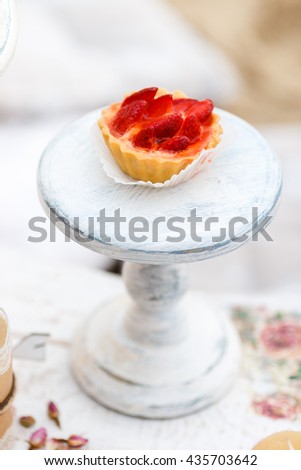 Sweet and delicious cake with strawberries on a stand. Shabby chic style