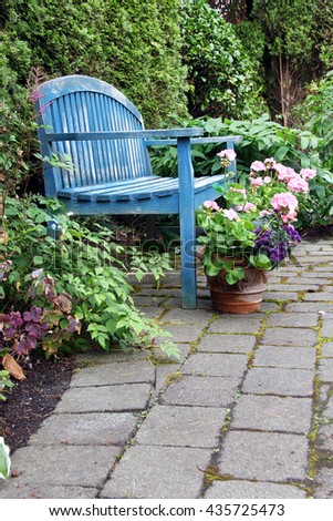 Rustic garden bench and pink geraniums