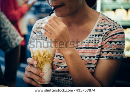 girl sitting on stairs in coffee shop and drinking ice coffee
