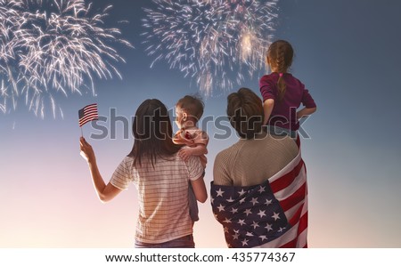 Patriotic holiday. Happy family, parents and daughters children girls with American flag outdoors. USA celebrate 4th of July. Royalty-Free Stock Photo #435774367