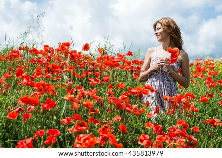 woman in field of red poppies
