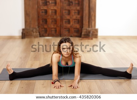 Woman yoga trainer in upavishta (wide angle seated) pose