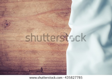 white tablecloth on wooden background , vintage filter