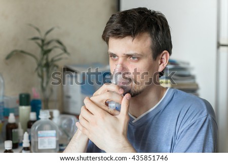 Portrait Of Young Man Inhaling Through Inhaler Mask Royalty-Free Stock Photo #435851746
