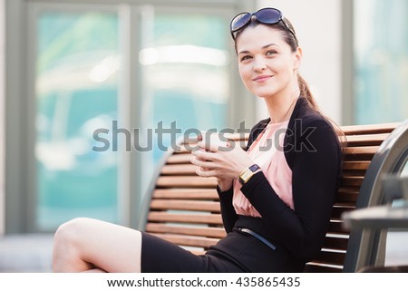Business woman enjoying coffee break on the bench
