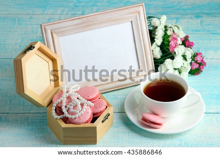 open wooden box on wooden background with macaroon and beads near to the Cup of strong coffee and flowers