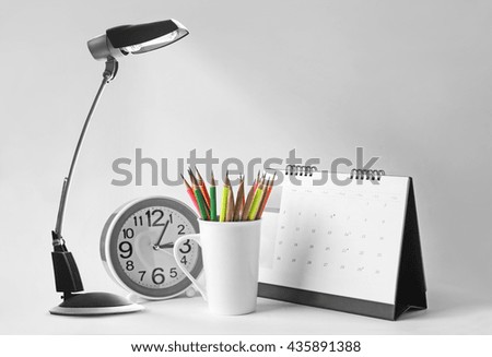 Table lamps, cups, pencils, calendars, desk clock shot in a studio.