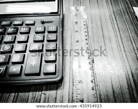Black and White picture : Calculator and ruler on the table   