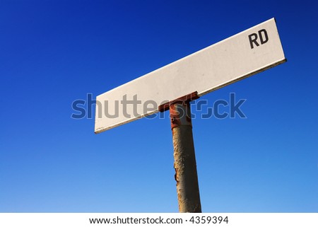Weathered old road sign against a clear blue sky - Space for text