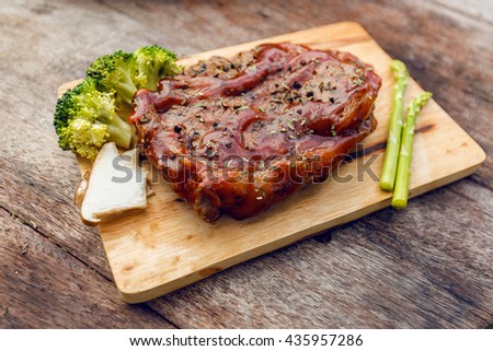 Steak and vegetables on wooden plates .