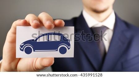 Businessman holding business card with picture of car