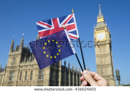 Hand waving European Union and British Union Jack flag in front of Big Ben and the Houses of Parliament at Westminster Palace, London as the Brexit process moves ahead Royalty-Free Stock Photo #436024603