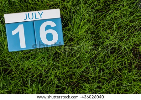 July 16th. Image of july 16 wooden color calendar on greengrass lawn background. Summer day, empty space for text