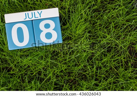 July 8th. Image of july 8 wooden color calendar on greengrass lawn background. Summer day, empty space for text