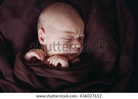 Little Sleeping Cute Newborn Baby. Brown background